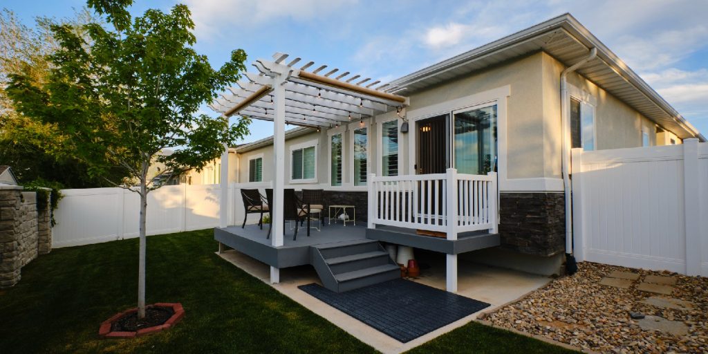 A backyard of a suburban USA home with a deck and pergola.