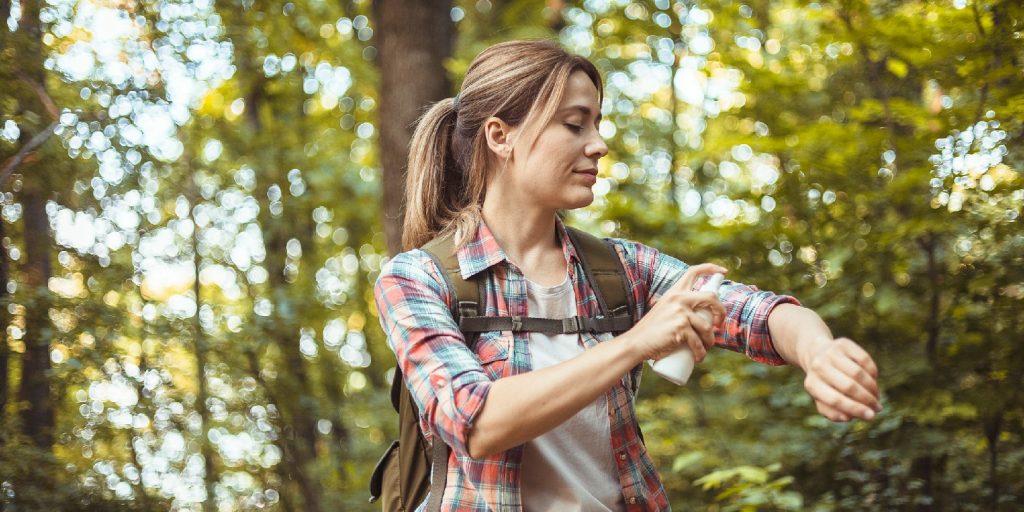 Woman Applying Insect Repellent Against Mosquito and Tick During Hike in Nature. Skin Protection Against Insect Bite