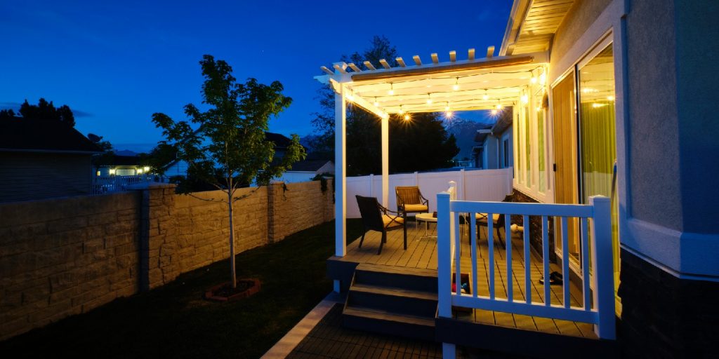 A backyard of a suburban USA home with a deck and pergola.