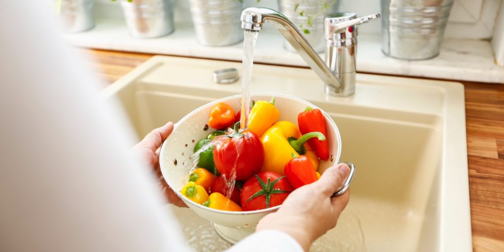 Housewife preparing vegetables for cooking in a domestic kitchen.