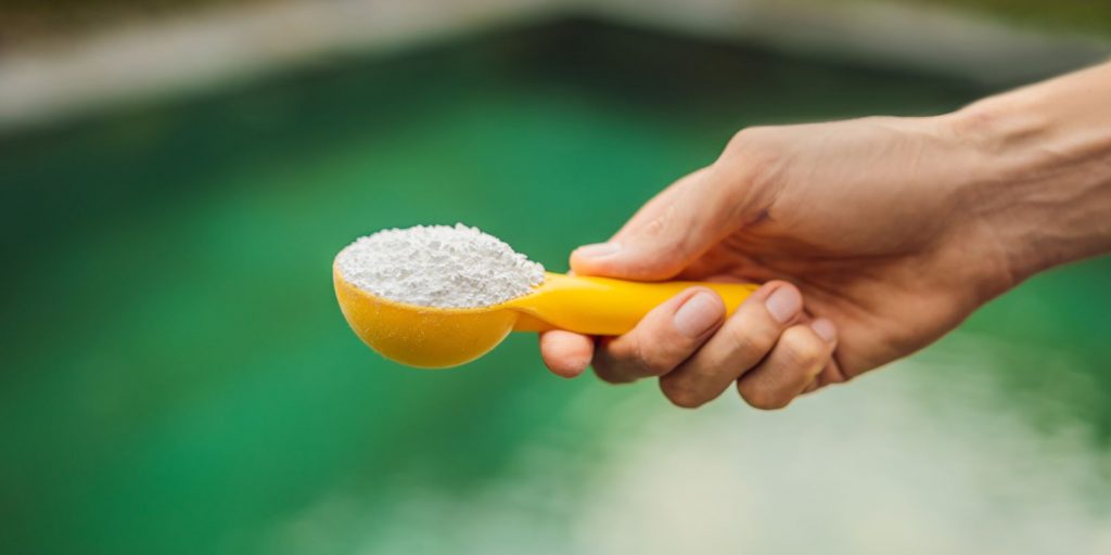 Hand Holding Chlorinefor Water in the Pool