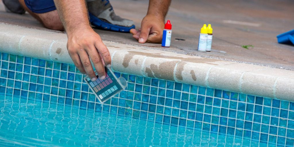 Pool testing kit being used in a swimming pool