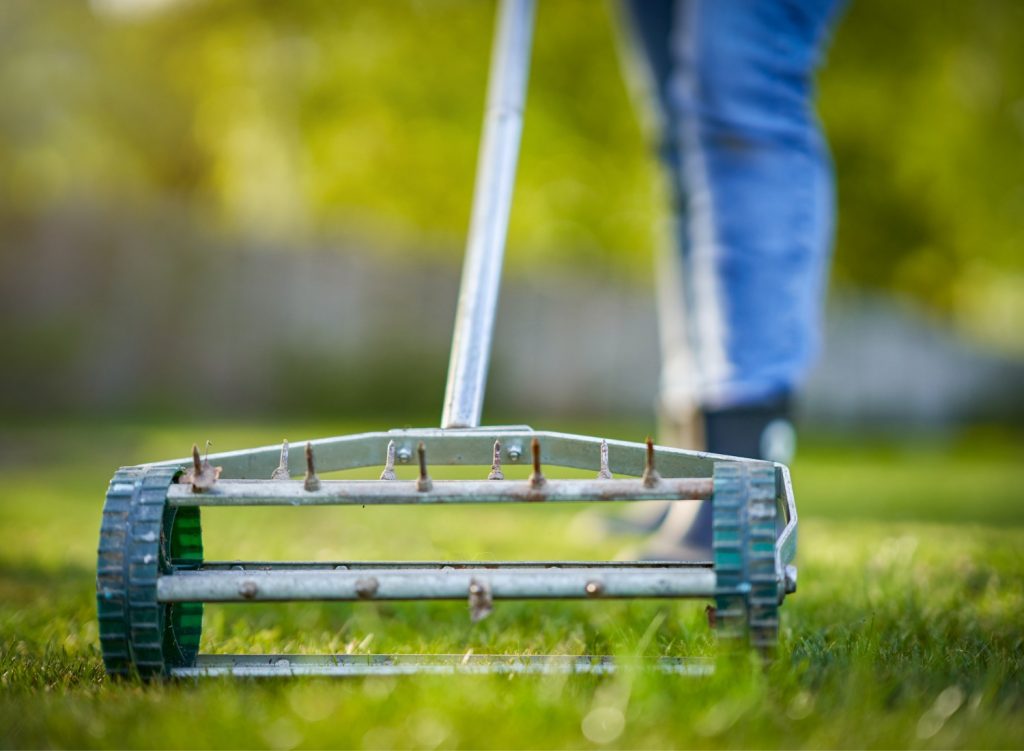 Person using aerator on a lawn