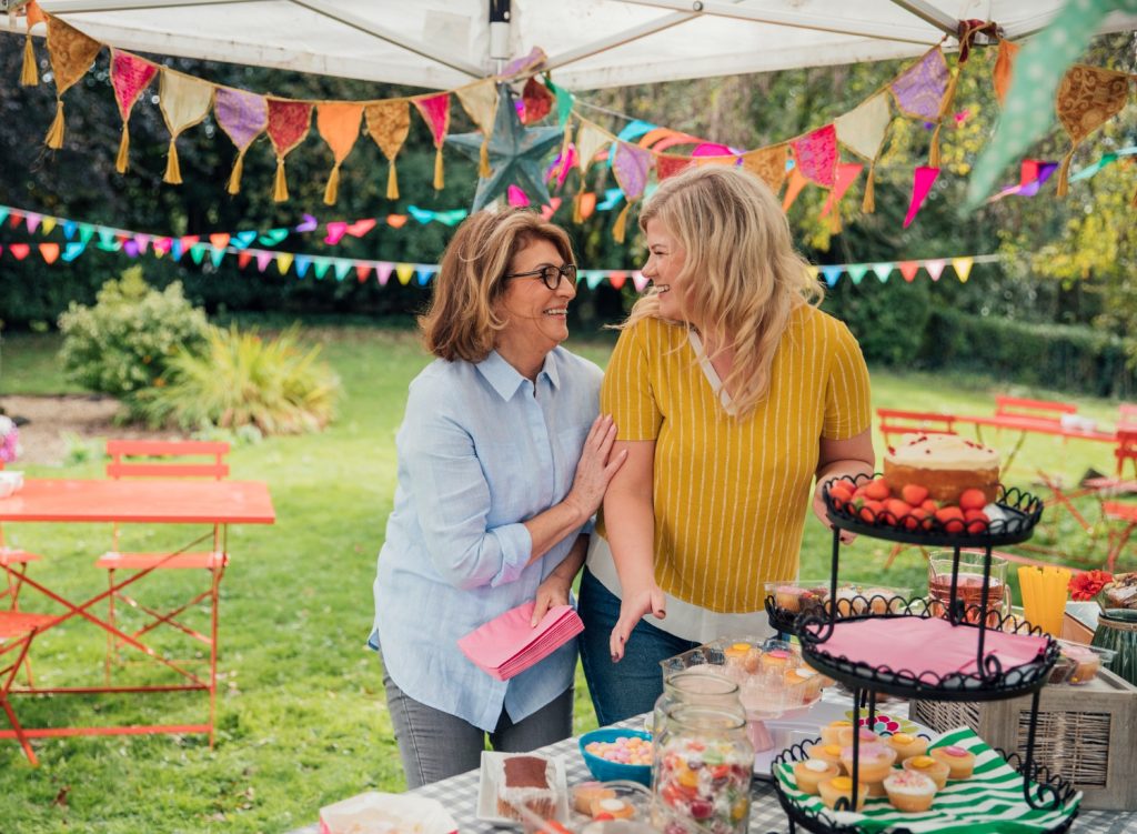 Women setting up a garden party under a canopy