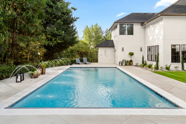 best pool backwash hose A rectangular swimming pool in the backyard of a black and white house.