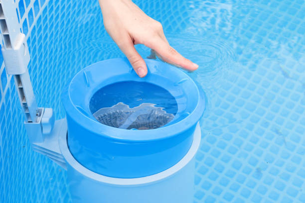 Automatic pool skimmer girl cleans skimmer for the frame pool. Contaminated pool cleaning concept.